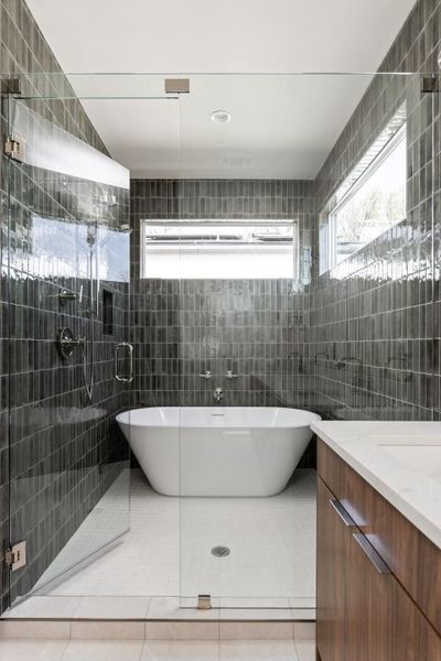 Bathroom with tile patterned floors, a shower stall, and tile walls