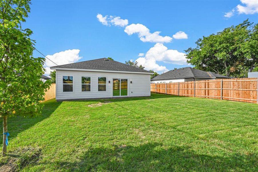 Rear view of property with a lawn