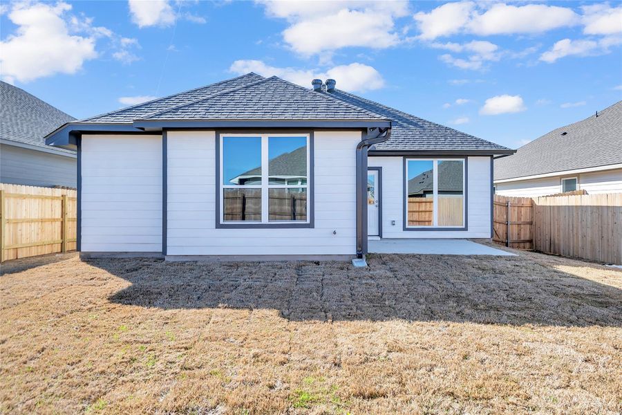 Back of property featuring a patio area, a yard, a fenced backyard, and roof with shingles