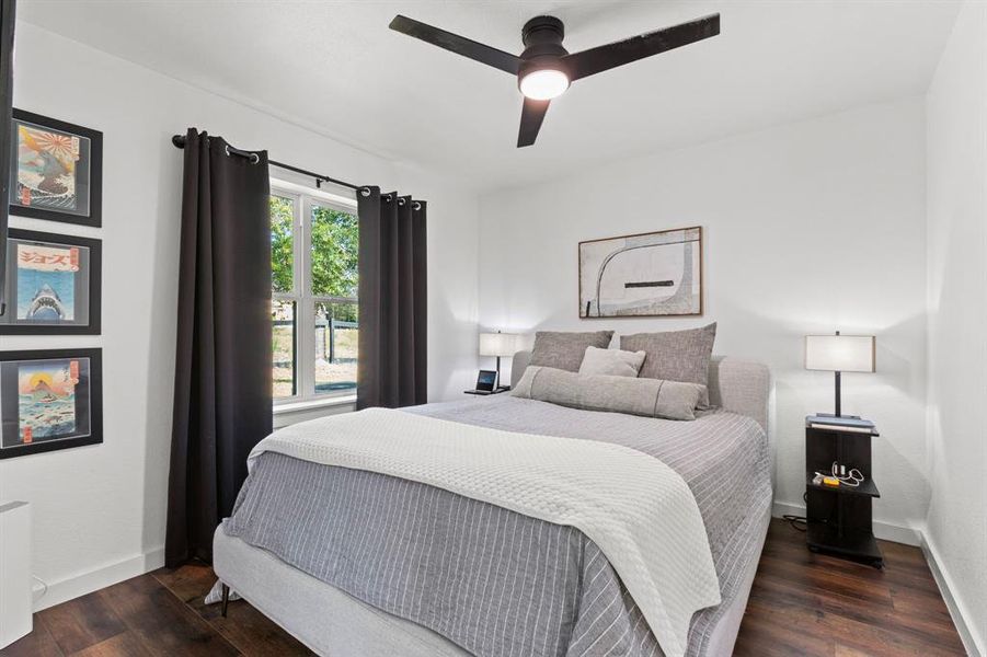 The first bedroom with beautiful picture views of the wooded outdoors behind the home.