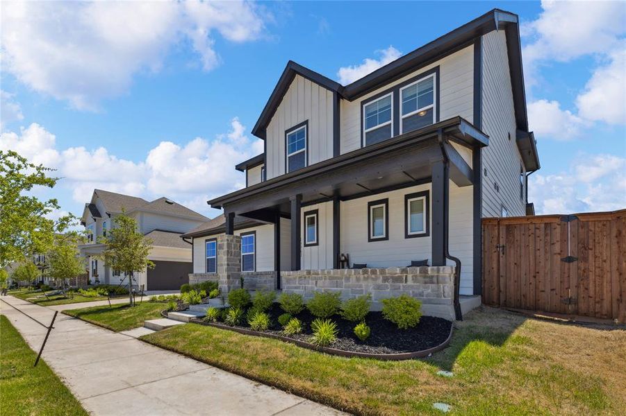 View of front of home with a gate, a porch, board and batten siding, and a front yard View of front of home with a gate, a porch, board and batten siding, and a front yard