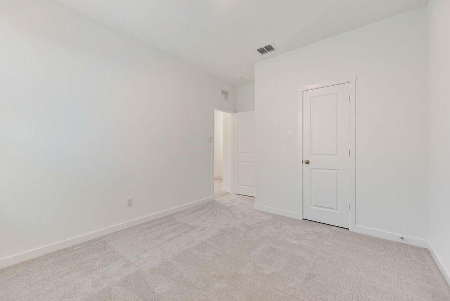 Empty room with light colored carpet and baseboards Empty room with light colored carpet and baseboards