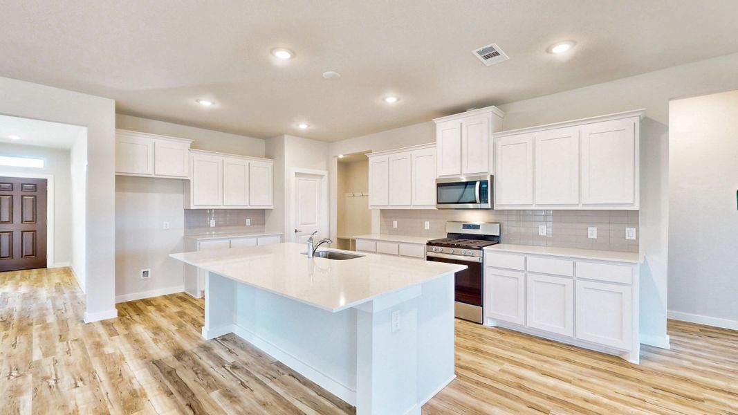 A kitchen with white cabinets.