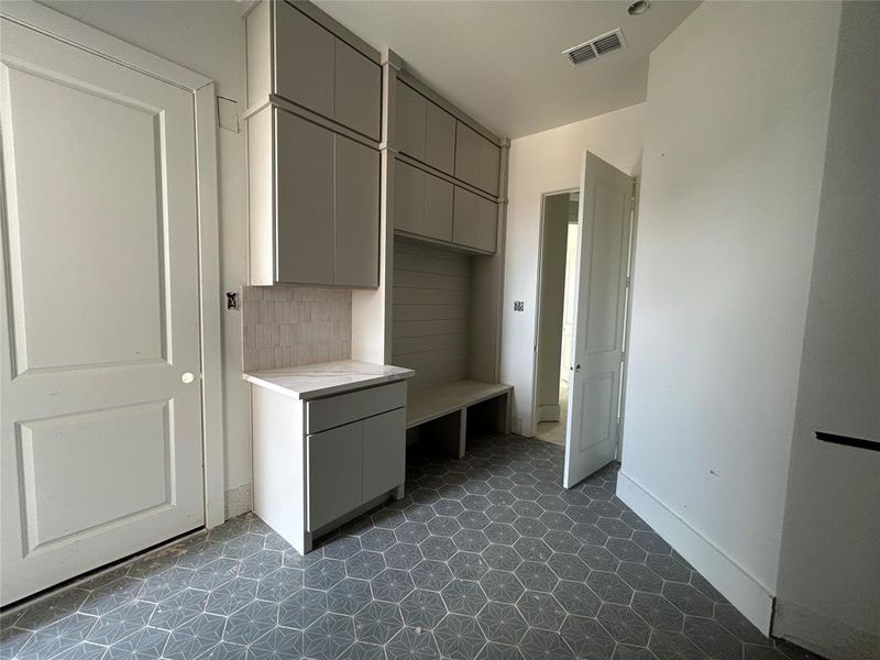 The utility room, conveniently located near the kitchen, offers ample space for laundry and storage needs.