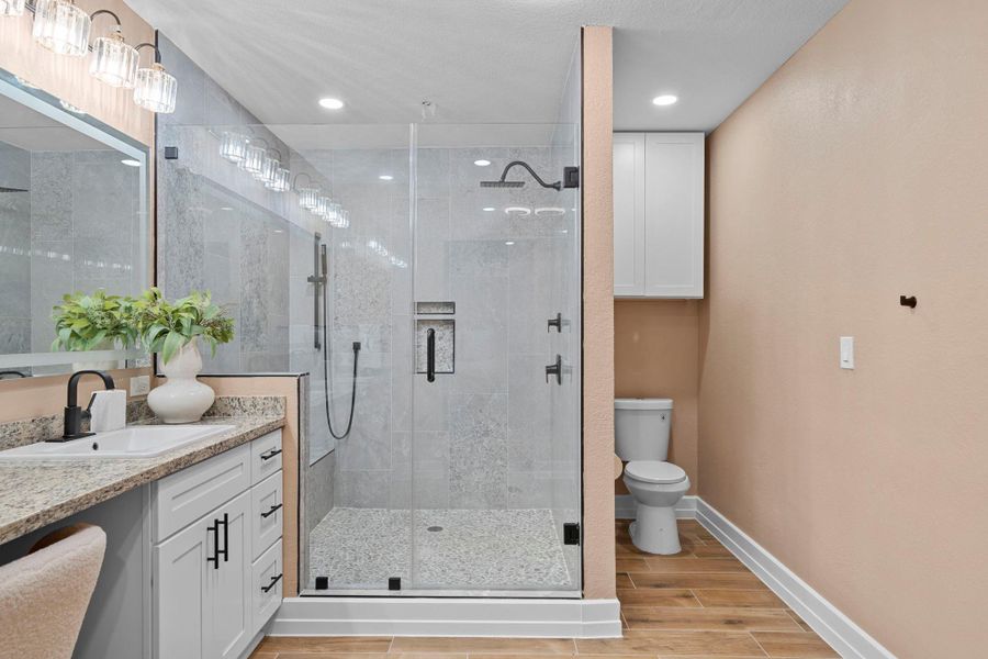 This primary bathroom is a spa-like retreat that masterfully continues the home’s high-end, modern rustic aesthetic.