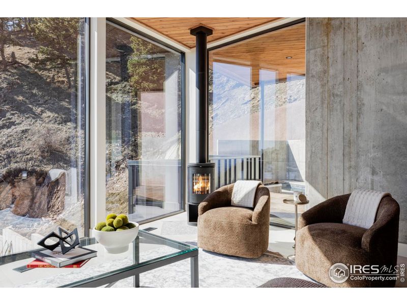 The main level is designed for relaxing and entertaining, featuring a great room with a chic circular wood-burning fireplace, and floor-to-ceiling and wall-to-wall windows frame views that sweep across the Boulder skyline and beyond. The main level is designed for relaxing and entertaining, featuring a great room with a chic circular wood-burning fireplace, and floor-to-ceiling and wall-to-wall windows frame views that sweep across the Boulder skyline and beyond.