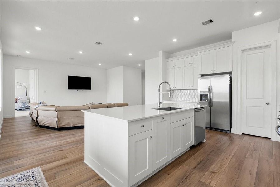 The chef’s eat-in island kitchen is the heart of the home, featuring lengthy quartz countertops, an abundance of upgraded cabinetry with crown molding, a designer backsplash, and stainless steel appliances. The chef’s eat-in island kitchen is the heart of the home, featuring lengthy quartz countertops, an abundance of upgraded cabinetry with crown molding, a designer backsplash, and stainless steel appliances.