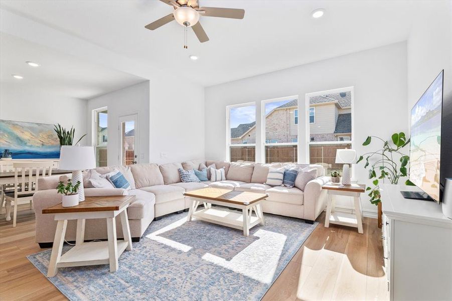 Bright living area featuring wood-finish flooring, recessed lighting, and a ceiling fan