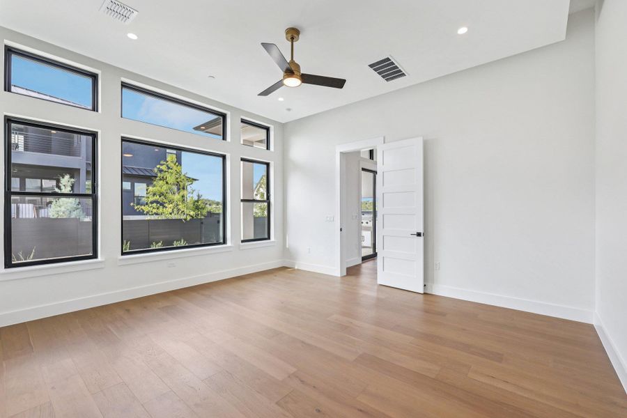 Primary bedroom featuring light wood finished floors, recessed lighting, and ceiling fan