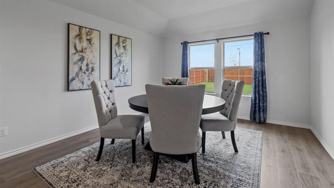 Dining area with wood finished floors and lofted ceiling Dining area with wood finished floors and lofted ceiling