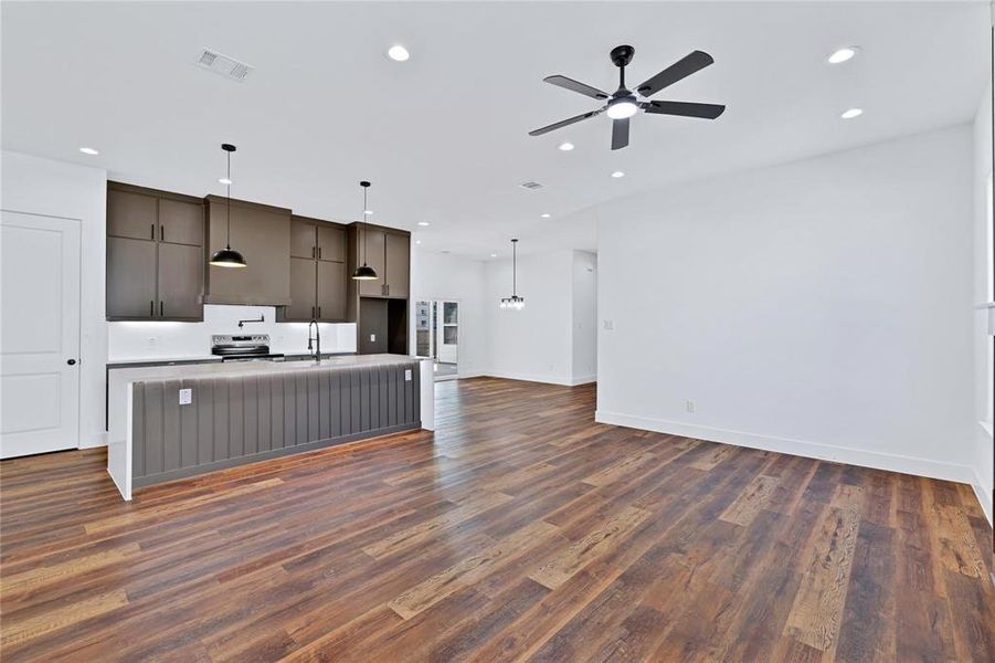 Unfurnished living room with dark wood-type flooring, a ceiling fan, and recessed lighting