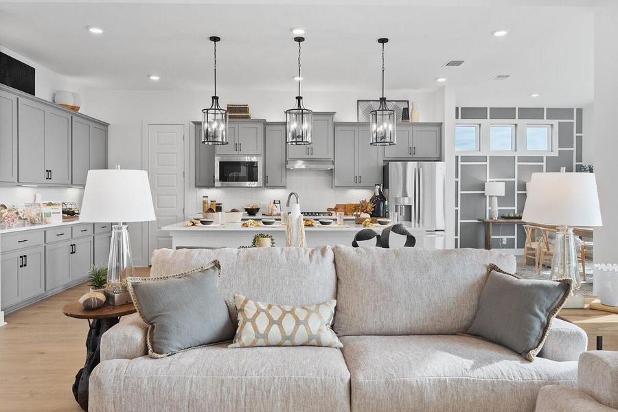 Living area with light wood finished floors and recessed lighting