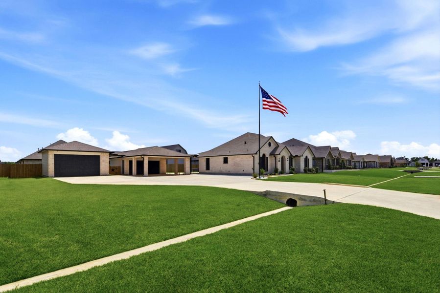 Front exterior of a new home in Pedregal, Dickinson, TX, highlighting curb appeal (Image 24).