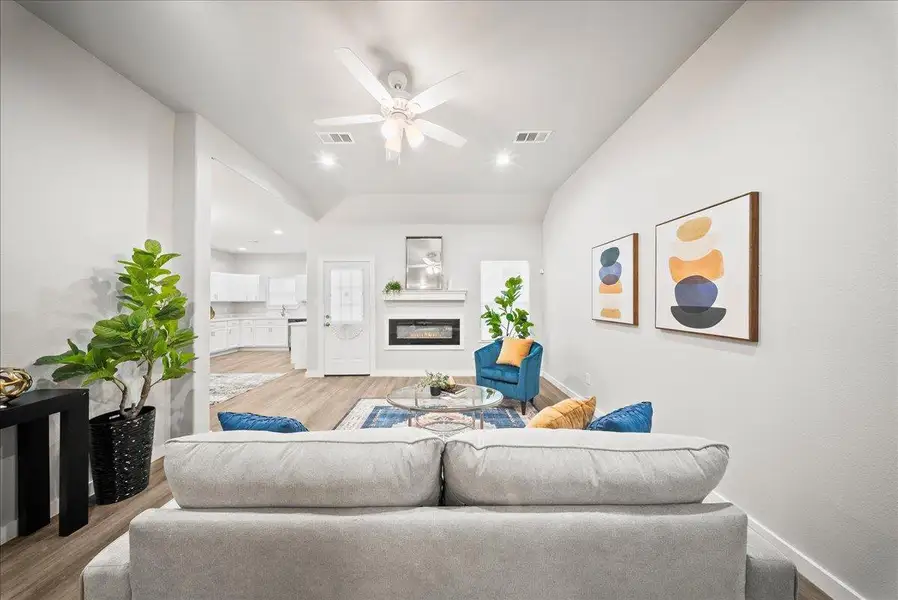 Living area with a glass covered fireplace, light wood finished floors, a ceiling fan, and recessed lighting Living area with a glass covered fireplace, light wood finished floors, a ceiling fan, and recessed lighting