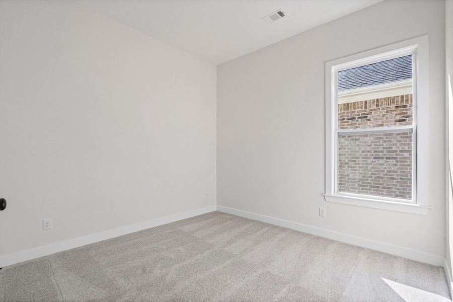Neutral wall finishes, light gray carpet, and a single-pane window with white trim