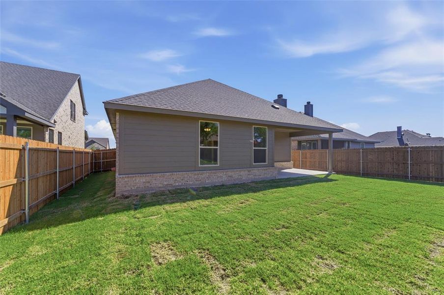 Back of house featuring a patio area, brick siding, a shingled roof, a fenced backyard, and a chimney