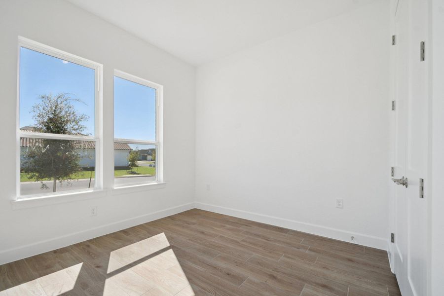 Spare room featuring baseboards and wood finished floors