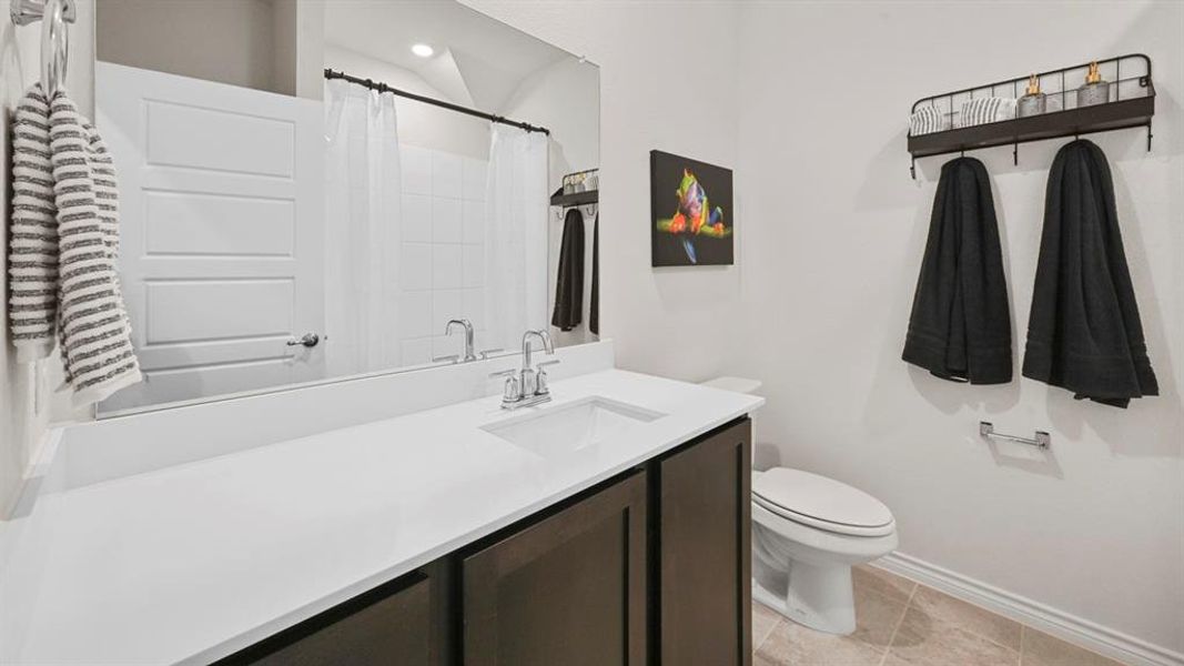 Bathroom with vanity, curtained shower, and light tile patterned floors