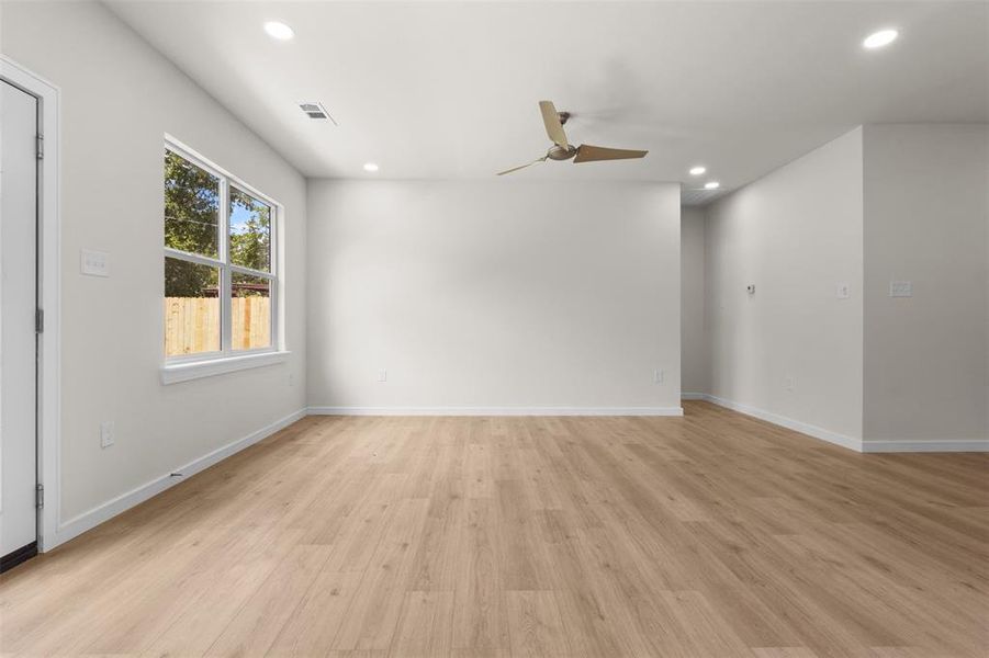 Open living space featuring wood-finish flooring, recessed lighting, and a ceiling fan