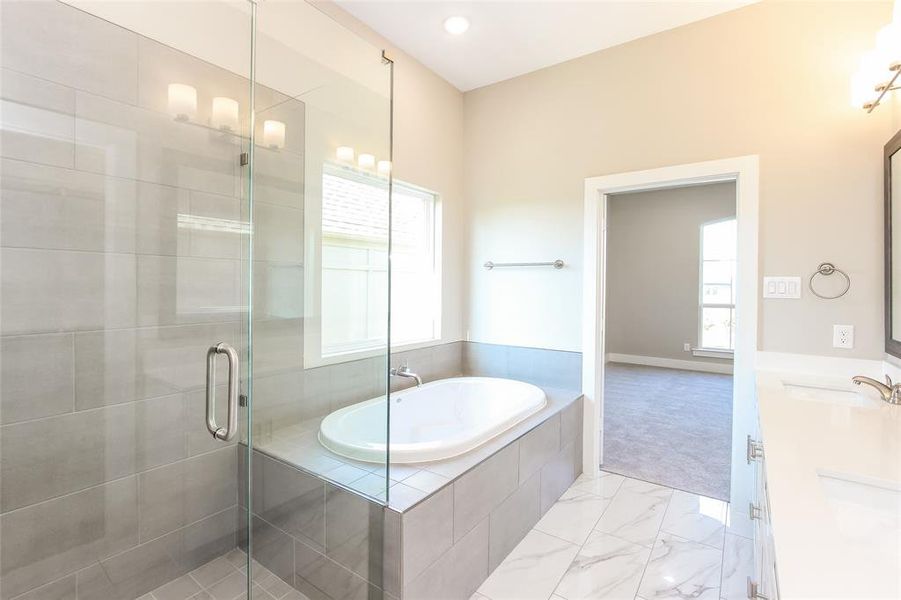 Bathroom featuring vanity and shower with separate bathtub