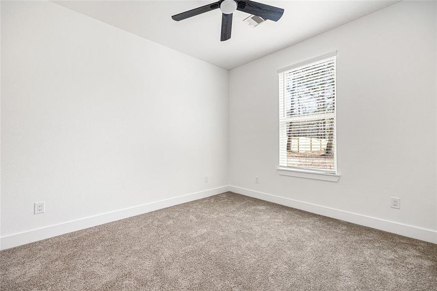 Bright and Airy BedroomThis spacious bedroom features large windows that bring in plenty of natural light, plush carpeting, and a modern ceiling fan. A cozy and inviting space perfect for rest and relaxation