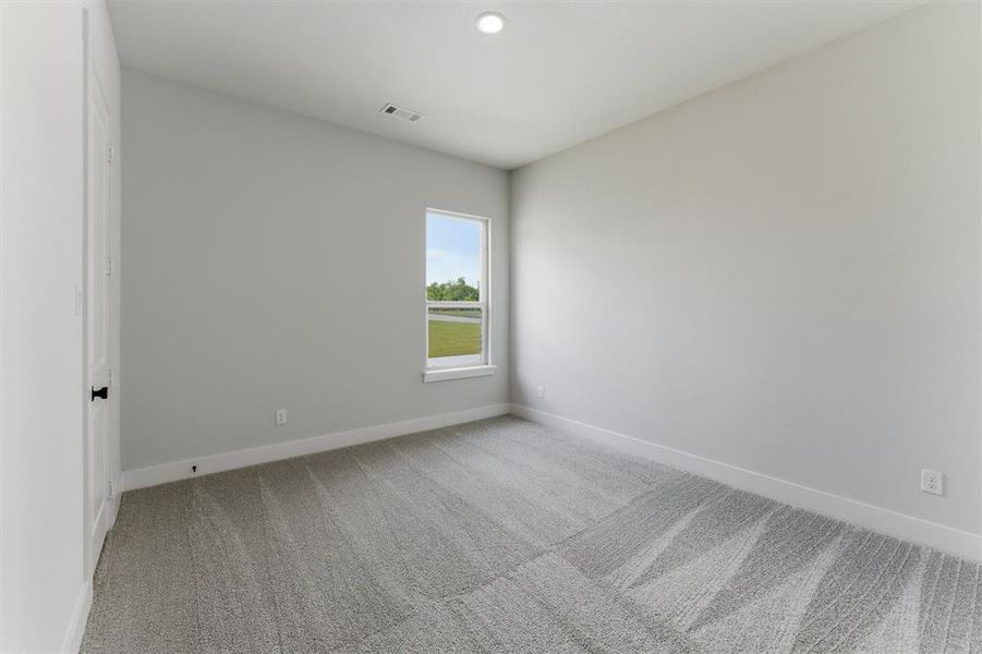 Neutral-toned room featuring a single window and recessed lighting