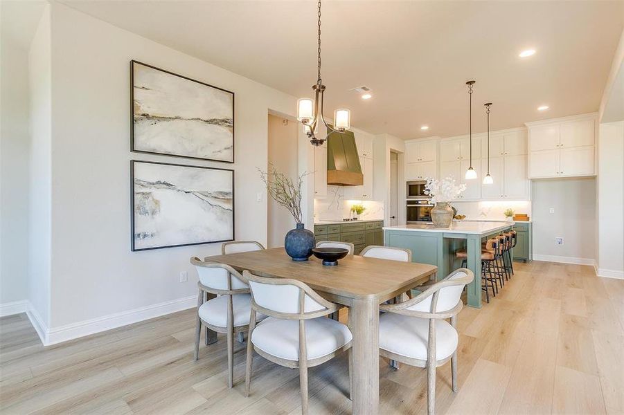 Dining space featuring a notable chandelier and light wood-type flooring