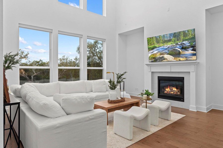 Living room featuring a high ceiling, a tile fireplace, a wealth of natural light, and dark hardwood / wood-style flooring