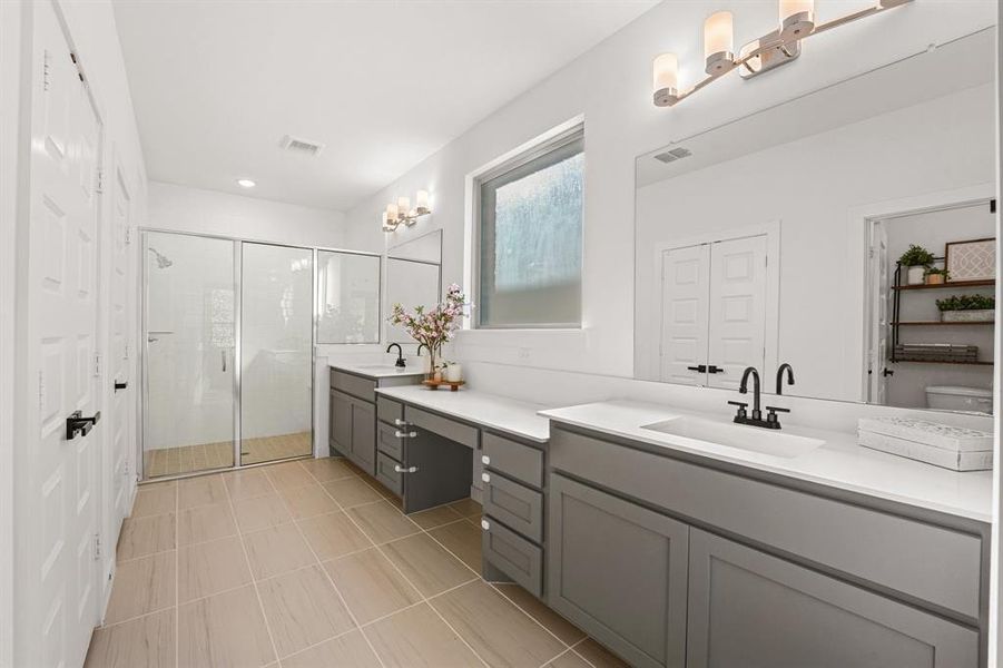 Bathroom with double vanity, a stall shower, a closet, a chandelier, and light tile patterned floors