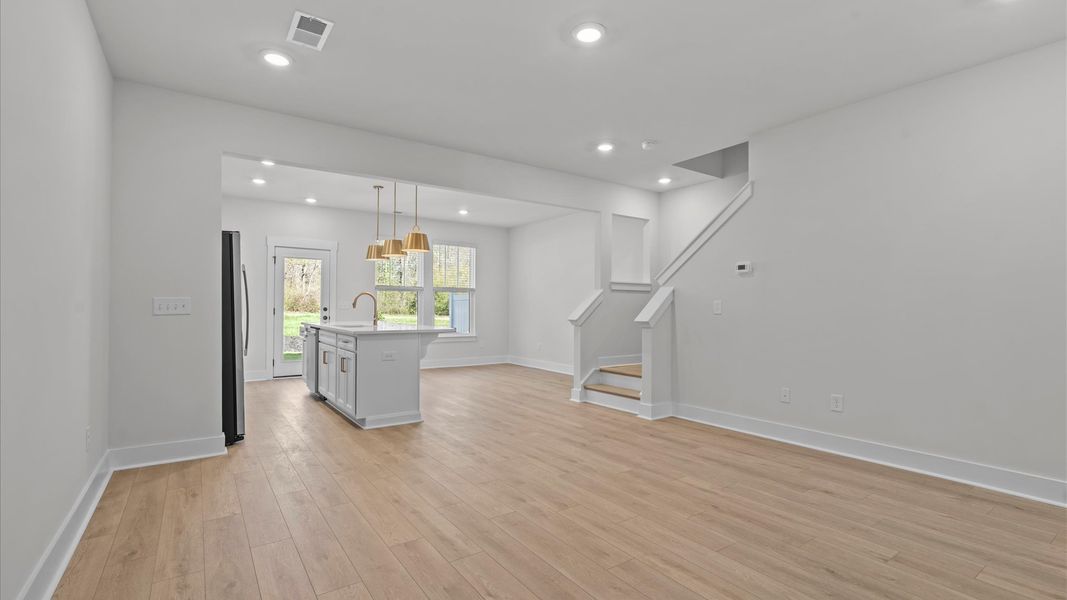 Elegant family room featuring hardwood flooring, large windows, and thoughtful architectural detail in Simpsonville, SC