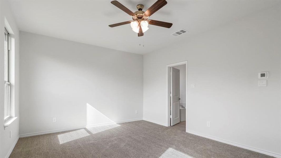 Spare room featuring light carpet and a ceiling fan