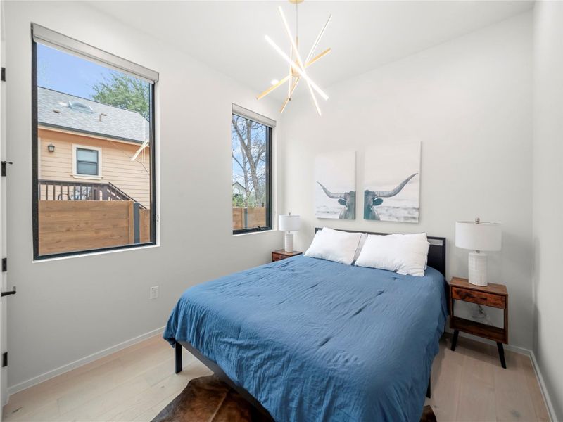 Bedroom featuring light wood finished floors and suspended lighting