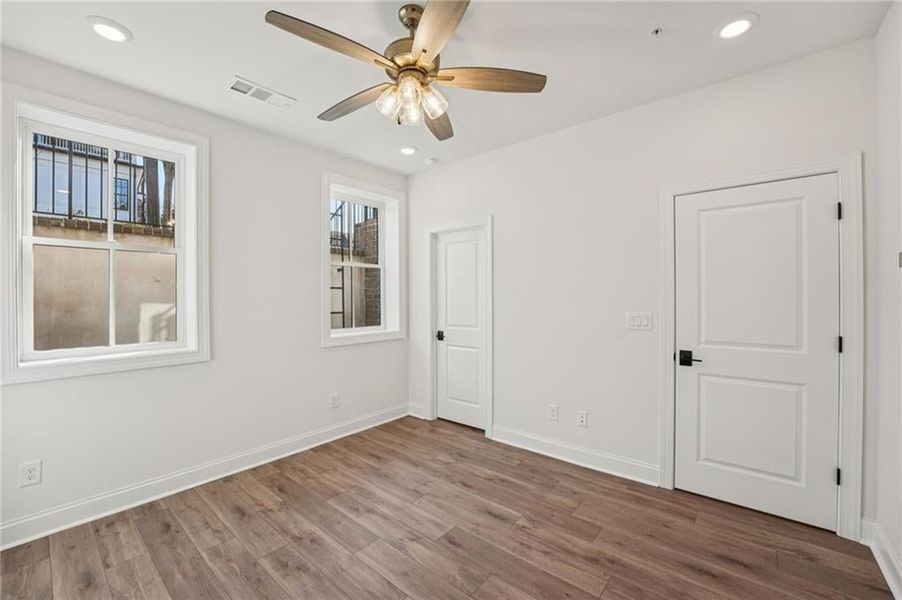 Unfurnished bedroom featuring recessed lighting, wood finished floors, and a ceiling fan Unfurnished bedroom featuring recessed lighting, wood finished floors, and a ceiling fan
