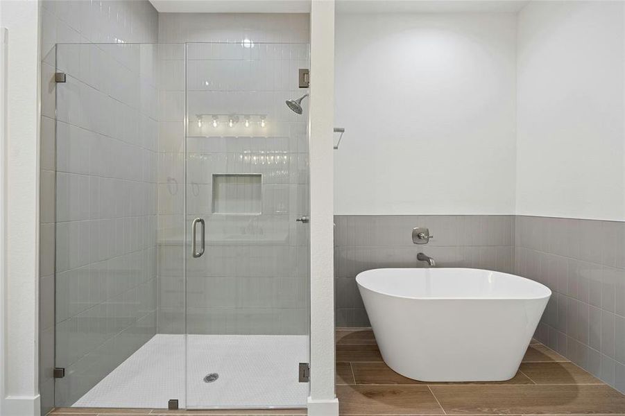 Primary bath has dual vanities, walk in shower, and soaking tub.