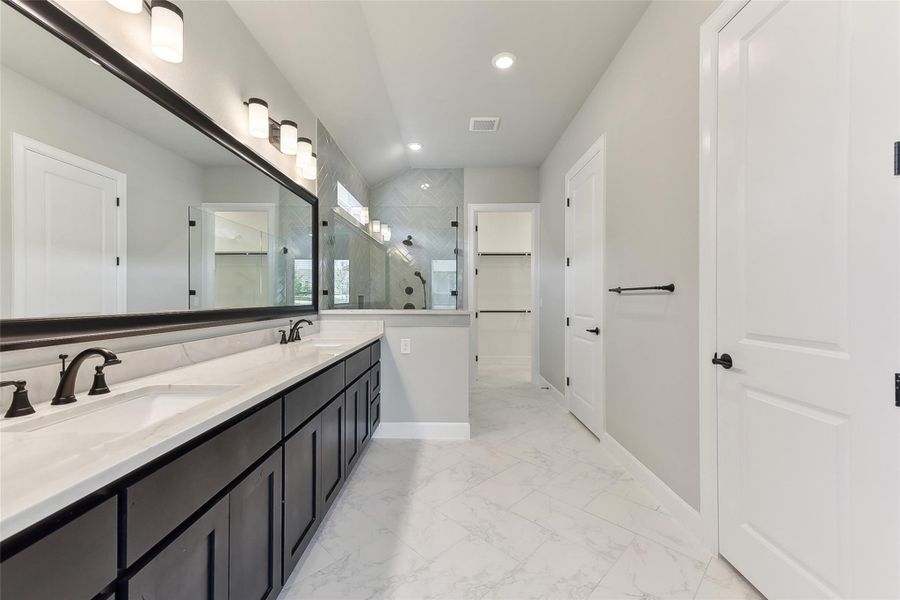 Bathroom featuring a shower stall, a walk in closet, recessed lighting, baseboards, and double vanity Bathroom featuring a shower stall, a walk in closet, recessed lighting, baseboards, and double vanity
