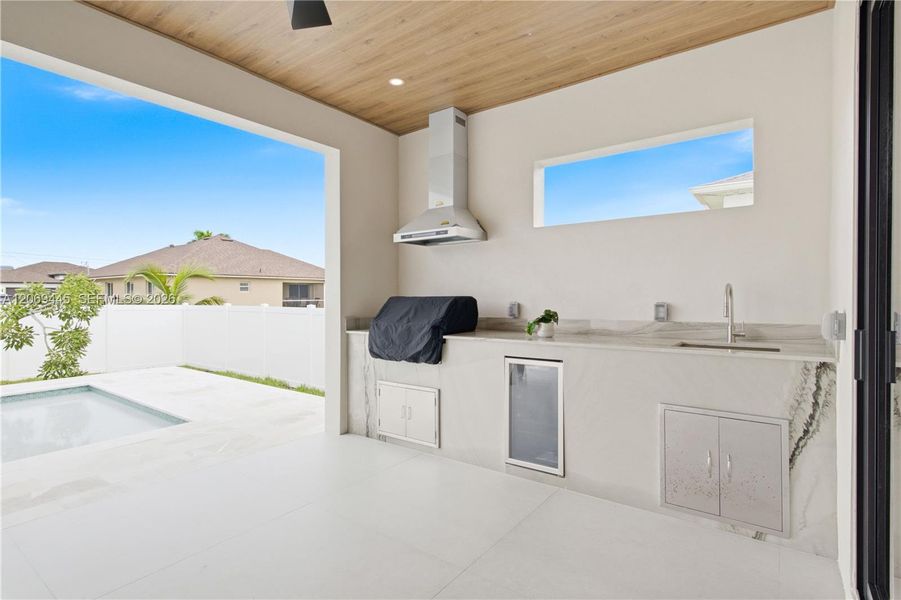 Built-in outdoor kitchen complete w/ grill, hood, sink, beverage refrigerator & storage Built-in outdoor kitchen complete w/ grill, hood, sink, beverage refrigerator & storage
