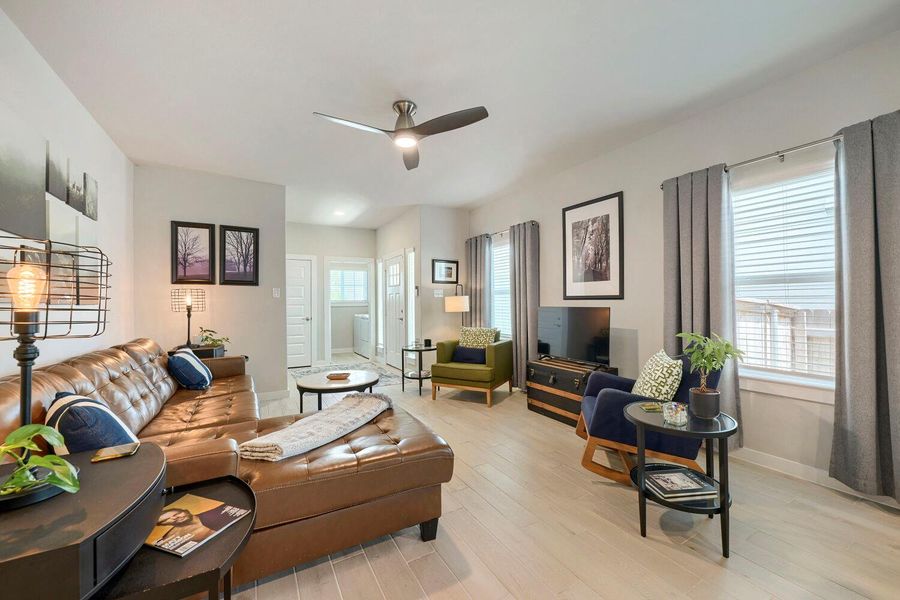 A welcoming living area boasts an overhead ceiling fan, seamlessly connecting to a bright hallway. A welcoming living area boasts an overhead ceiling fan, seamlessly connecting to a bright hallway.
