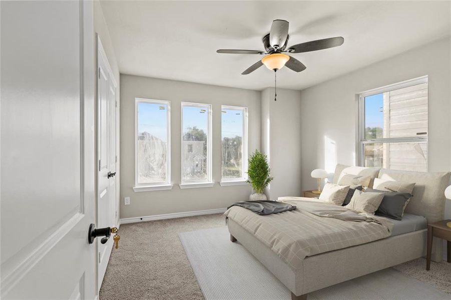 *Virtually Staged* Bedroom featuring multiple windows, ceiling fan, and light carpet