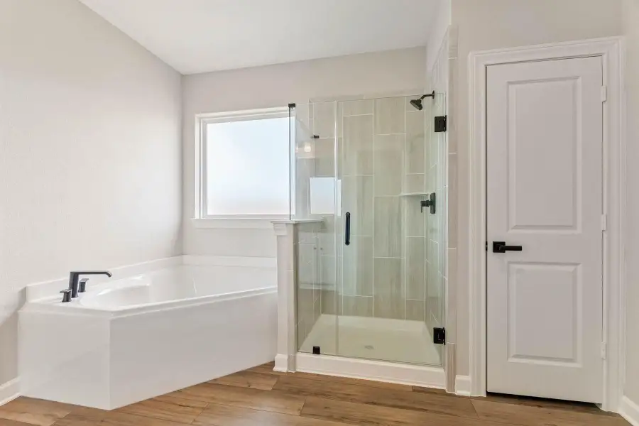 The primary bathroom has a luxurious soaking tub and separate shower.