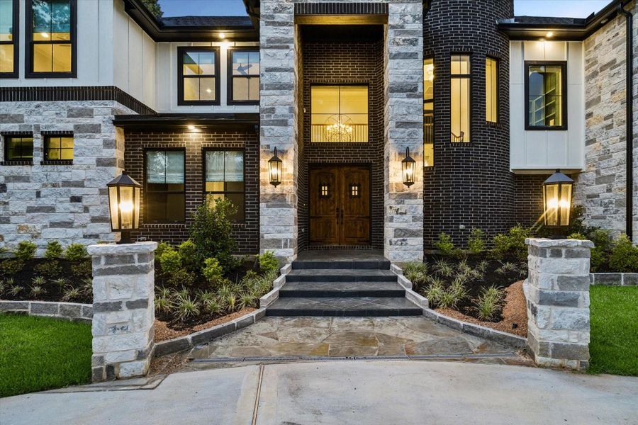The grand front entrance sets the tone for everything that follows. Castle-inspired solid wood double doors, dramatic stonework, and soaring rotunda architecture create an unforgettable sense of arrival. As guests approach the home, they are welcomed by timeless elegance, refined craftsmanship, and beautifully landscaped surroundings. Every detail has been intentionally designed to create a warm yet impressive introduction to one of the area's most exceptional custom luxury homes.