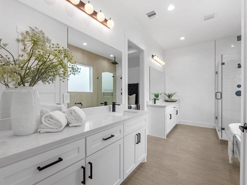 Separate counter and sink spaces offer ample room on both the countertops and in the cabinets, complemented by tasteful lighting and hardware.