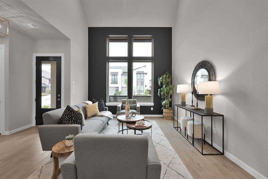 Soaring two-story ceilings and a dramatic wall of windows bring in abundant natural light. (Original Builder Staged Photo)