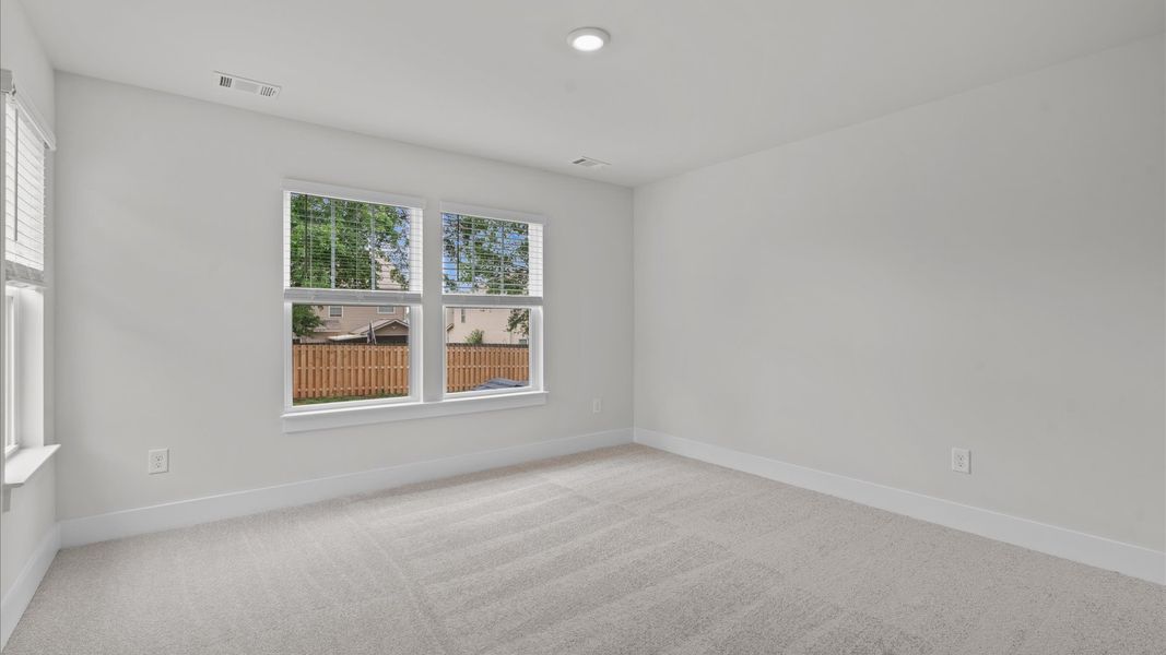 Carpeted secondary bedroom with large windows in two story townhome at Aspen Ridge by DRB Homes in Lyman, SC Carpeted secondary bedroom with large windows in two story townhome at Aspen Ridge by DRB Homes in Lyman, SC