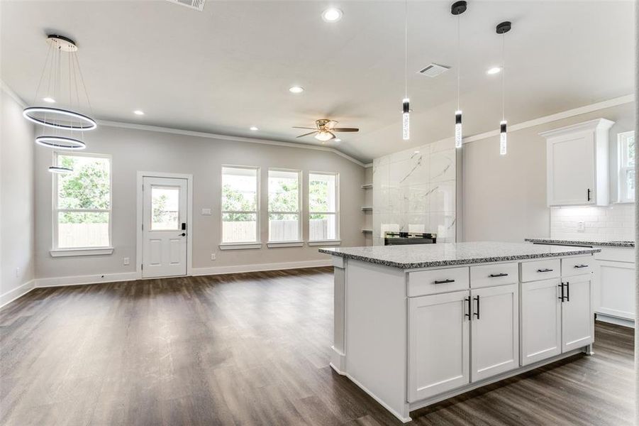 Kitchen featuring dark hardwood / wood-style flooring, tasteful backsplash, and plenty of natural light