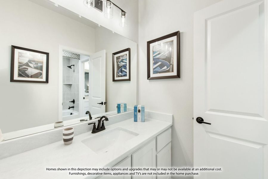 Bathroom with white vanity, dual sinks, large mirror, and tub-shower combo visible in reflection Bathroom with white vanity, dual sinks, large mirror, and tub-shower combo visible in reflection