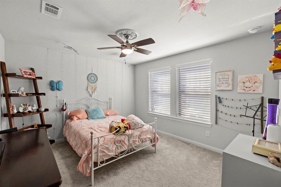 Bedroom featuring light carpet, ceiling fan, and a textured ceiling Bedroom featuring light carpet, ceiling fan, and a textured ceiling