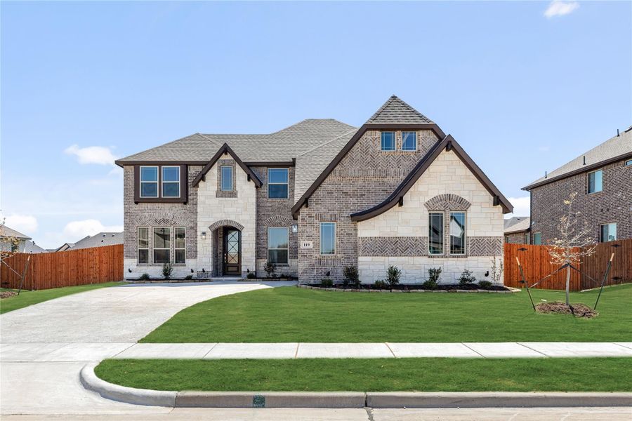 Two-story brick and stone home with arched entry, pitched roof, and manicured front lawn Two-story brick and stone home with arched entry, pitched roof, and manicured front lawn