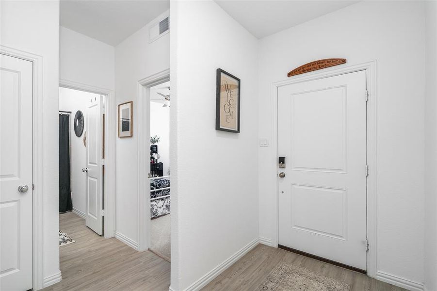 Entrance area featuring light-colored flooring, white walls, and a white paneled door