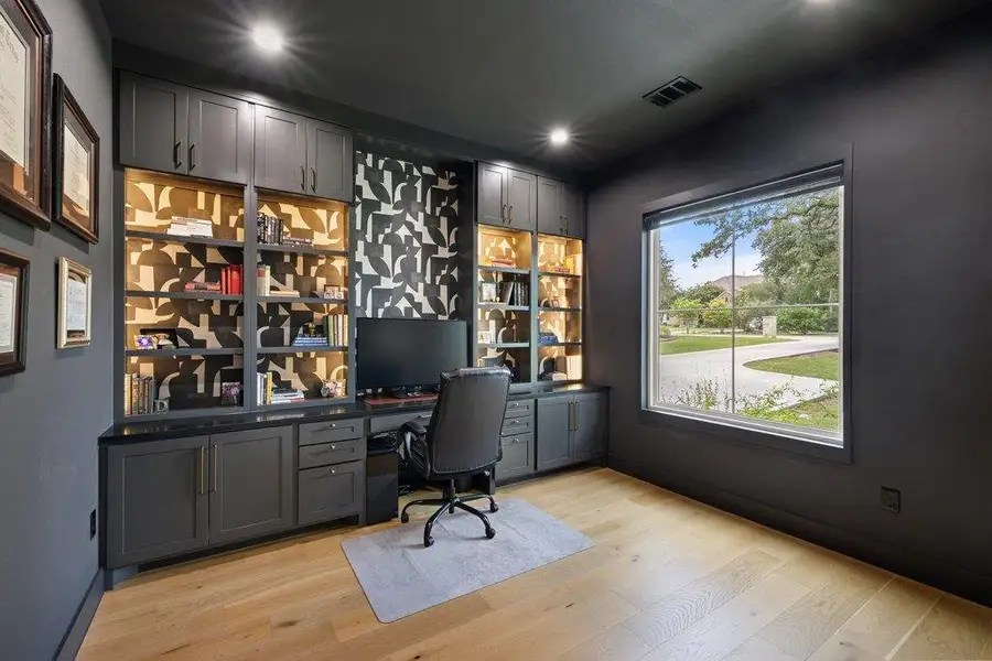 An inviting study features rich cabinetry and built-in shelving, providing a productive work-from-home environment. An inviting study features rich cabinetry and built-in shelving, providing a productive work-from-home environment.