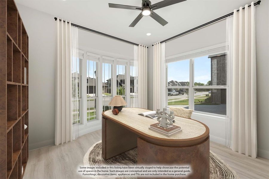 Home office with curved wood desk, ceiling fan, large windows, and built-in shelving unit
